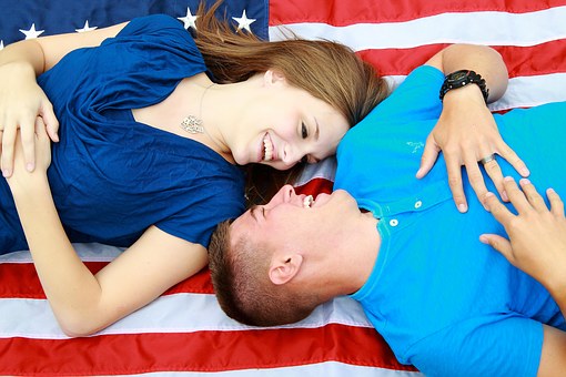 Couples laying over American flag